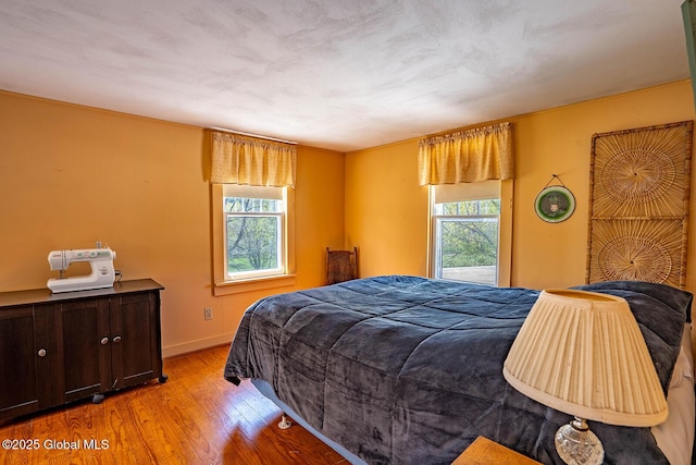 bedroom featuring baseboards and wood finished floors
