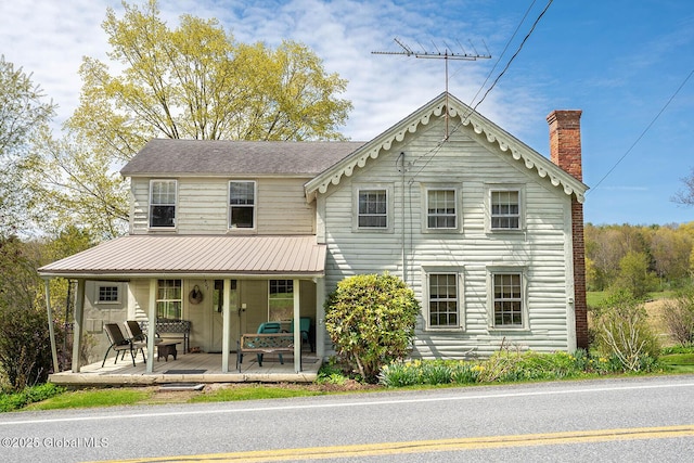 view of front of property with a porch and a chimney