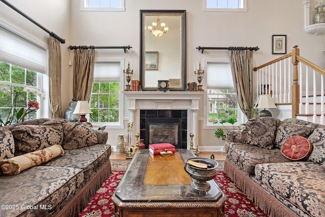 living area with plenty of natural light, a tile fireplace, and a high ceiling