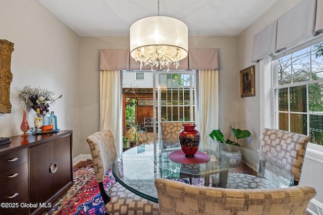 dining space with a chandelier, baseboards, and healthy amount of natural light