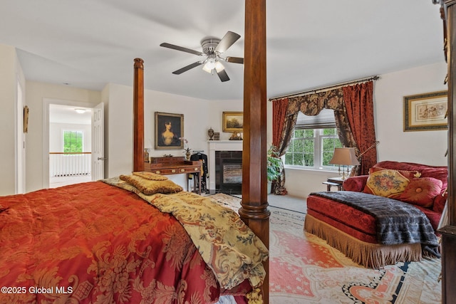 bedroom featuring a fireplace and a ceiling fan