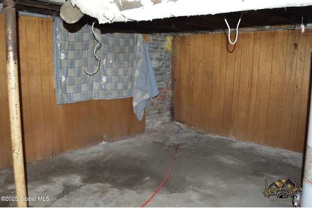 unfinished basement featuring wooden walls