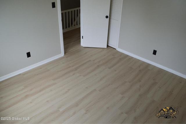 empty room with baseboards and wood finished floors