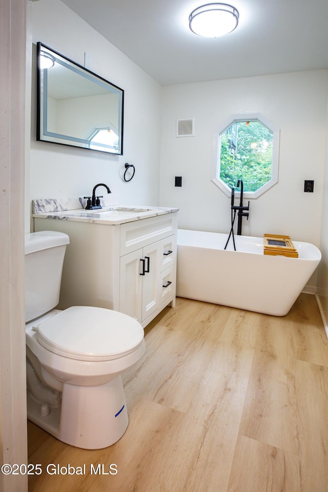 37 Nelson Ave, Rensselaer, NY 12144 - full bath with a freestanding tub, wood finished floors, vanity, and toilet