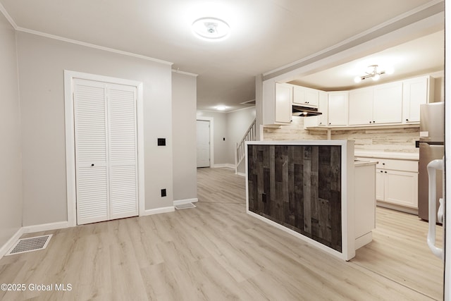 37 Nelson Ave, Rensselaer, NY 12144 - kitchen featuring light wood-type flooring, white cabinetry, crown molding, light countertops, and freestanding refrigerator