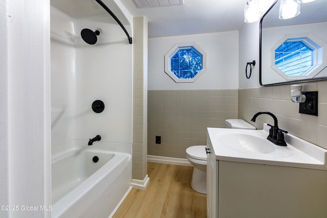 37 Nelson Ave, Rensselaer, NY 12144 - full bath with tile walls, wood finished floors, toilet, vanity, and bathing tub / shower combination