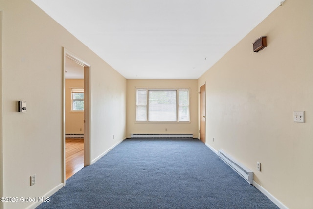 spare room with a baseboard heating unit, carpet floors, and baseboards
