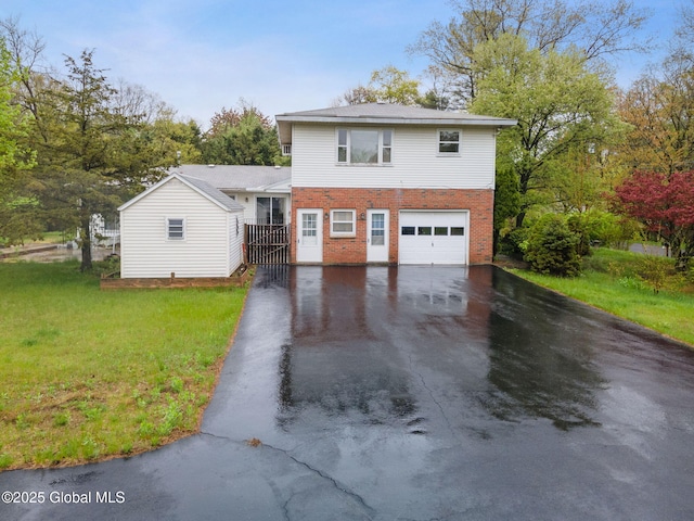view of front of home featuring driveway, brick siding, an attached garage, and a front yard