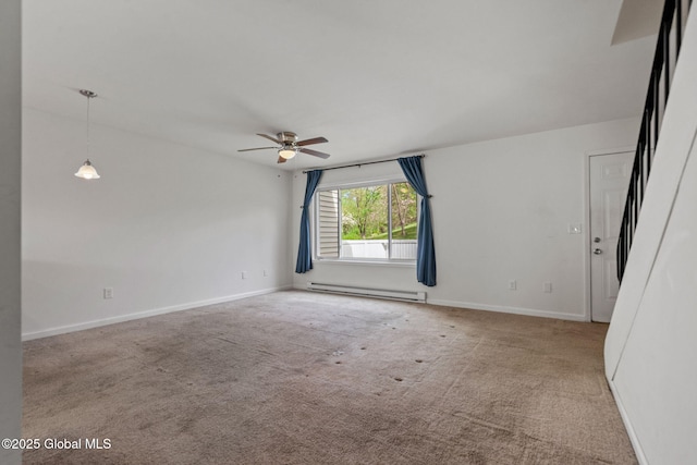 spare room with a ceiling fan, carpet flooring, baseboard heating, and baseboards