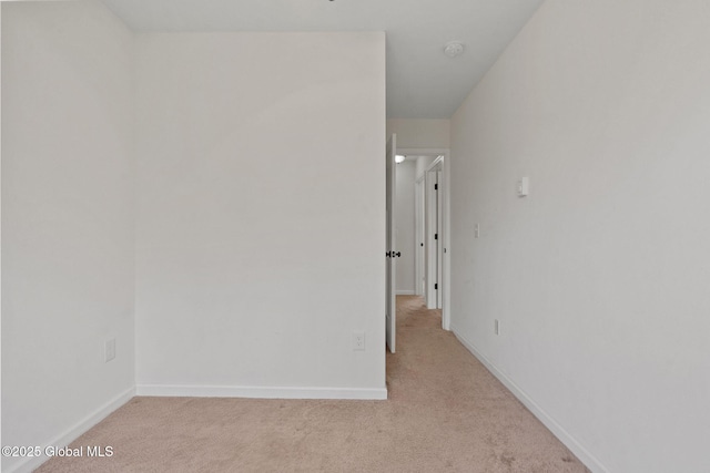 spare room with baseboards and carpet floors