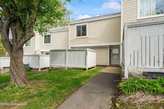exterior space with fence and a lawn