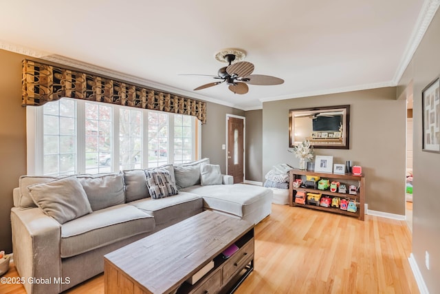 living room with a ceiling fan, baseboards, light wood-style flooring, and ornamental molding