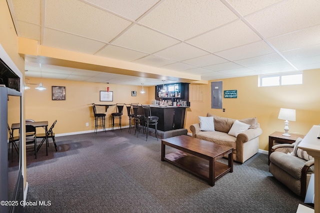 living room featuring a drop ceiling, a bar, carpet, and electric panel