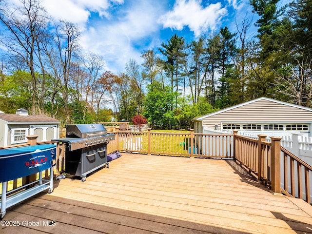 wooden terrace with an outbuilding and a grill
