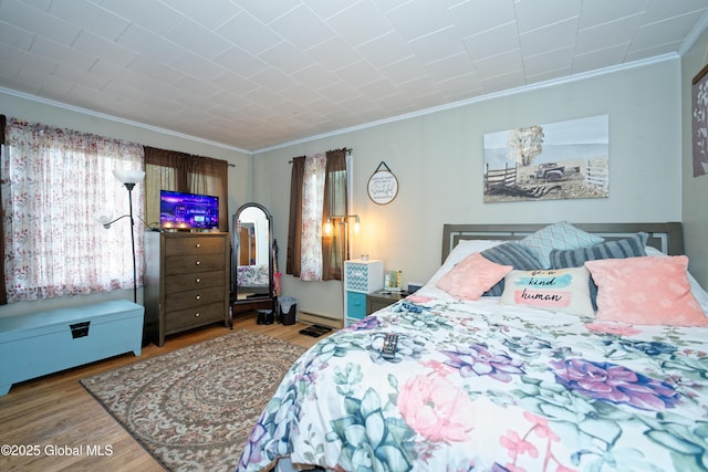 bedroom featuring ornamental molding and wood finished floors