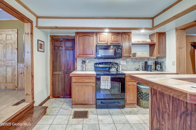 kitchen featuring black appliances, tile countertops, backsplash, and open shelves