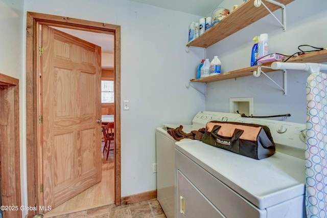 laundry area with separate washer and dryer and baseboards