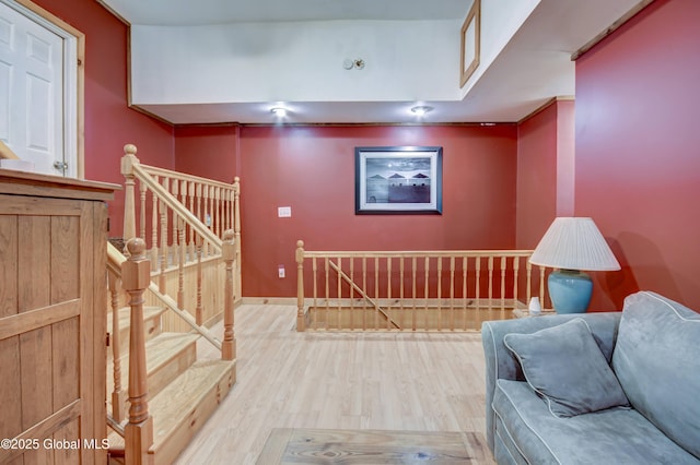 interior space featuring an upstairs landing, wood finished floors, and baseboards