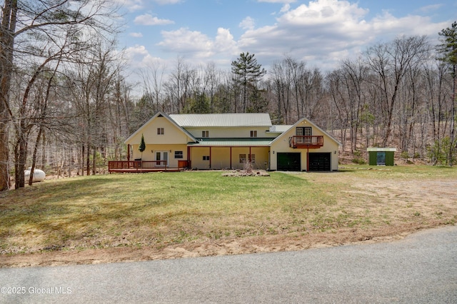 view of front of home with a front yard, metal roof, and a deck