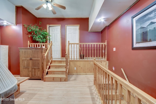 corridor featuring an upstairs landing and wood finished floors