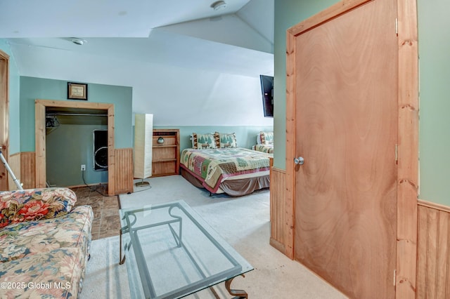 carpeted bedroom with lofted ceiling and a closet