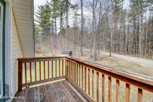 deck featuring a lawn and view of scattered trees