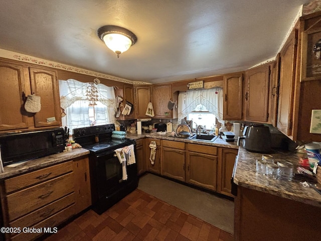 kitchen featuring a sink, plenty of natural light, black appliances, and brown cabinets
