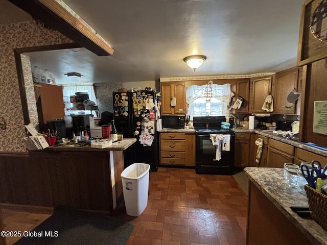 kitchen featuring brick patterned floor, brown cabinets, black appliances, and wallpapered walls