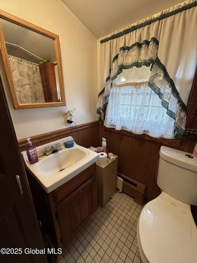 bathroom featuring vanity, a wainscoted wall, a baseboard heating unit, and toilet