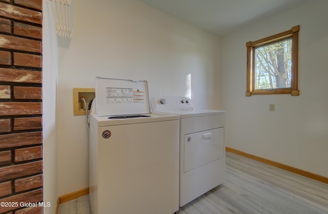 washroom featuring baseboards, separate washer and dryer, laundry area, and light wood-style flooring