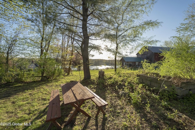 view of community with a water view and an outdoor structure