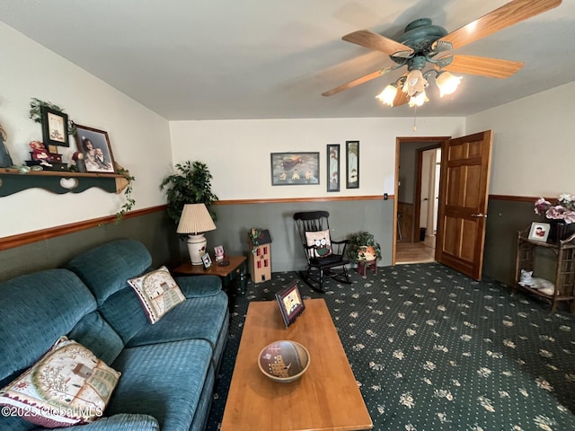living area featuring a ceiling fan and carpet
