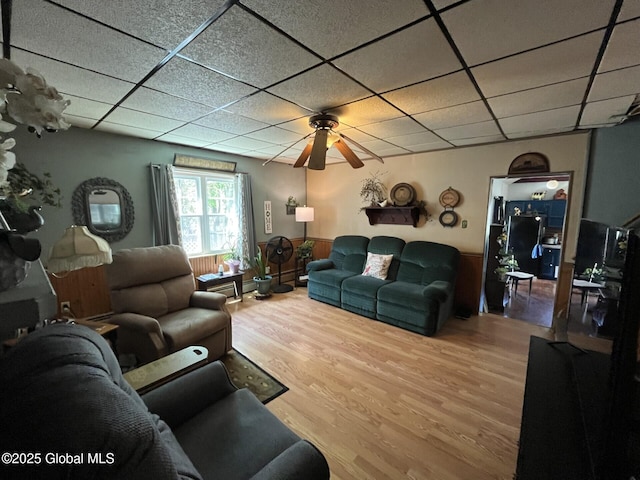 living room with ceiling fan, a paneled ceiling, and wood finished floors
