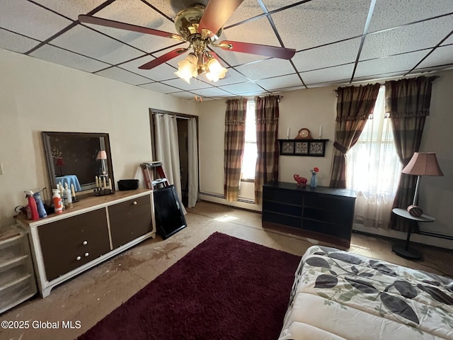 bedroom with a paneled ceiling and baseboard heating