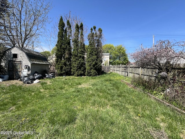view of yard featuring fence and an outbuilding