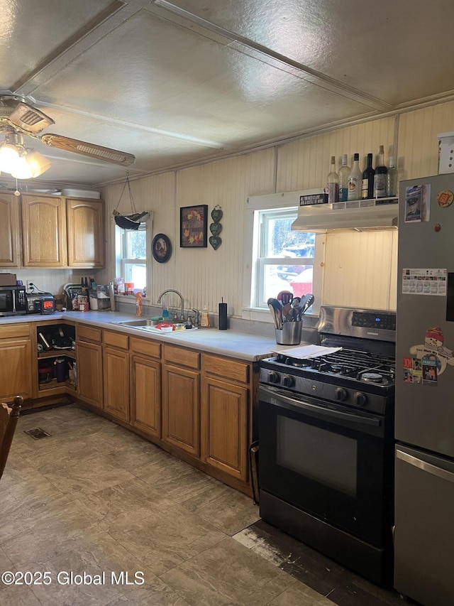 10 Valley View Ln, Moriah, NY 12956 - kitchen with gas stove, a sink, freestanding refrigerator, under cabinet range hood, and a wealth of natural light