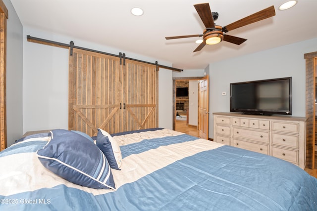 bedroom featuring recessed lighting, a ceiling fan, and a barn door
