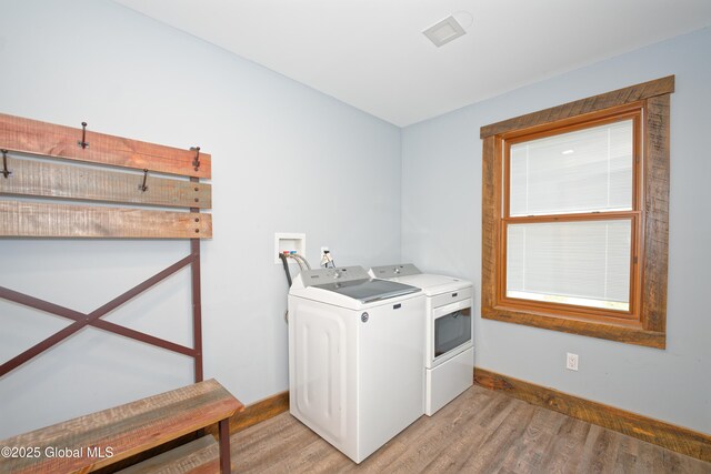 laundry area with baseboards, separate washer and dryer, laundry area, and light wood-style flooring