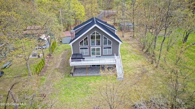 back of house with a lawn, stairs, a deck, and a wooded view