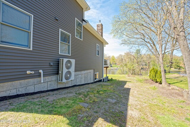 view of property exterior with a water view, ac unit, and a chimney
