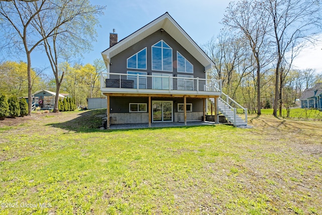 rear view of property with a lawn, stairway, a wooden deck, and a chimney