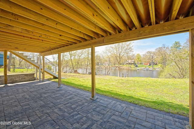 view of patio featuring a water view and stairway