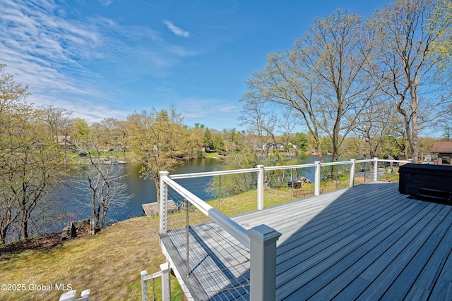 wooden terrace featuring a water view and a yard