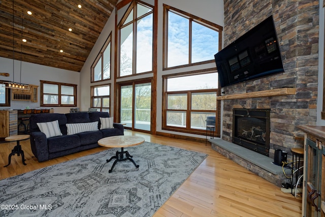 living area featuring wood-type flooring, a fireplace, high vaulted ceiling, recessed lighting, and wood ceiling