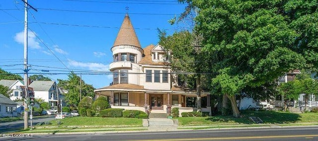 victorian-style house featuring a front lawn and covered porch