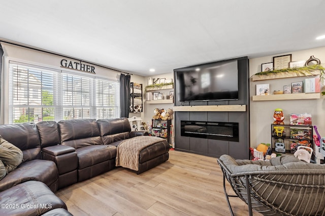 living area featuring a large fireplace, recessed lighting, and wood finished floors