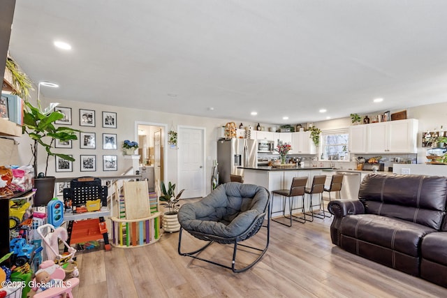 living room with light wood-type flooring and recessed lighting