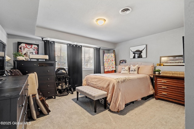 carpeted bedroom featuring visible vents