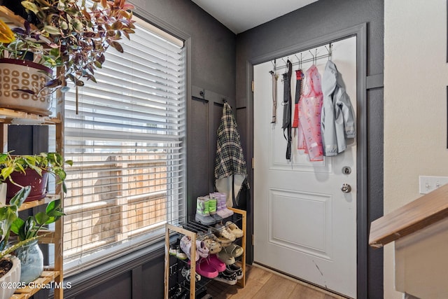 doorway featuring plenty of natural light, a textured wall, and light wood finished floors