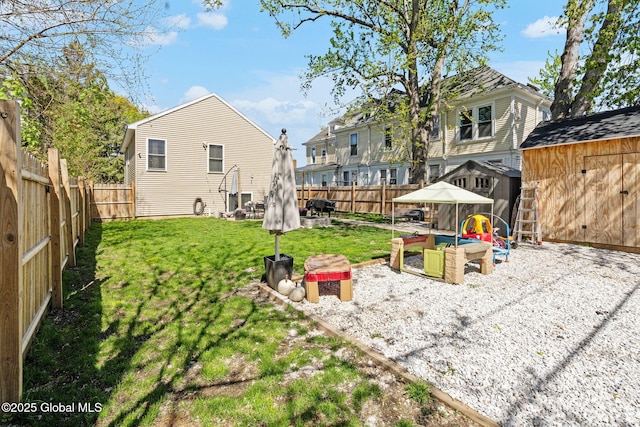 view of yard with a fenced backyard, a storage unit, an outdoor structure, and a patio